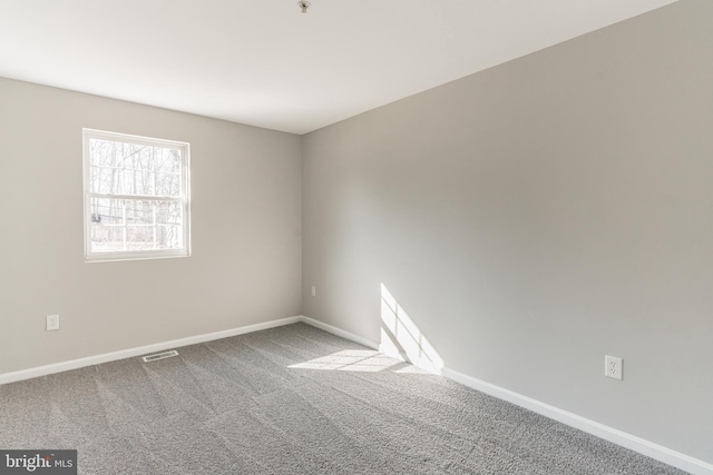 spare room with baseboards, visible vents, and carpet flooring