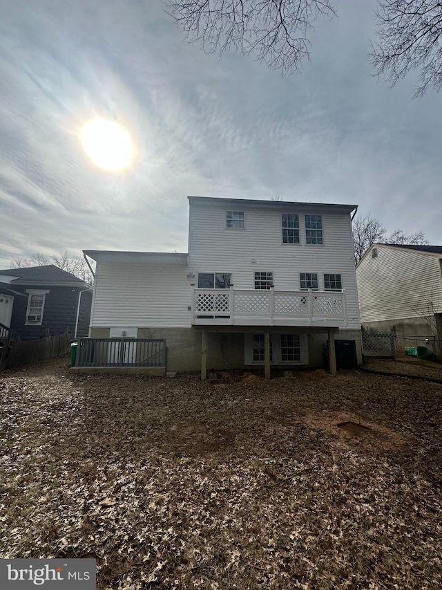 rear view of property with fence and a deck