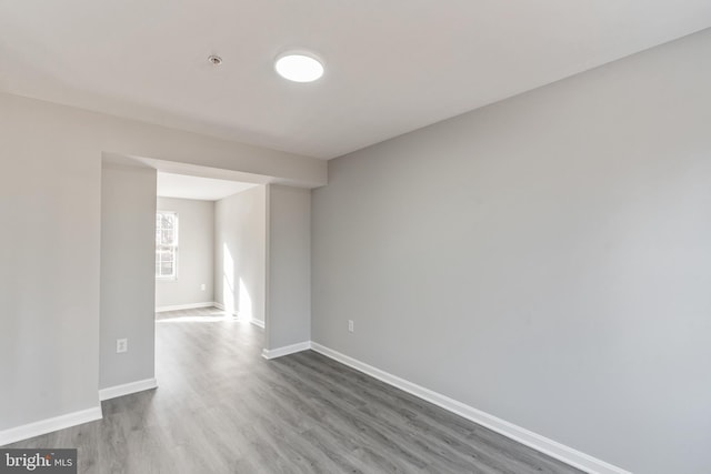 empty room with baseboards and wood finished floors