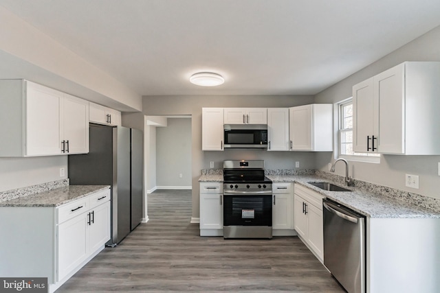 kitchen featuring stainless steel appliances, white cabinets, and a sink