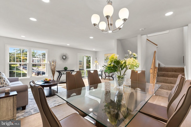 dining area featuring light wood-type flooring and a notable chandelier