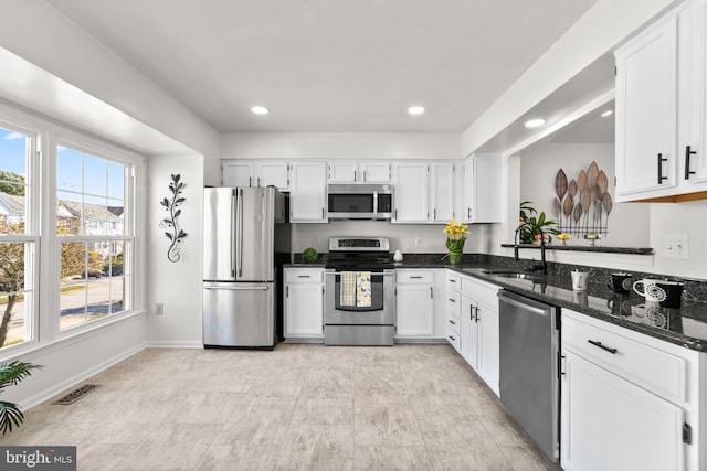 kitchen with white cabinetry, dark stone countertops, sink, and stainless steel appliances