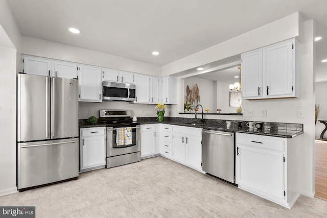 kitchen featuring appliances with stainless steel finishes, white cabinetry, and sink