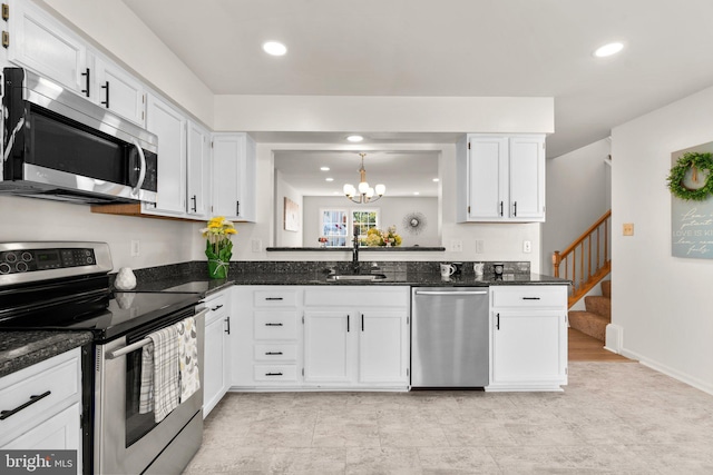 kitchen with sink, appliances with stainless steel finishes, white cabinets, and dark stone counters