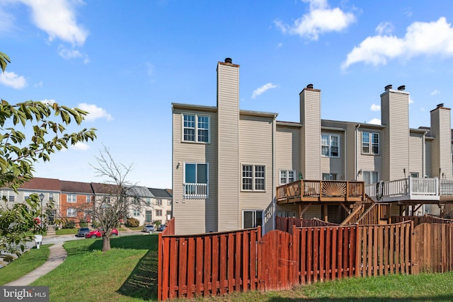 back of property featuring a yard and a wooden deck