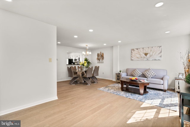 living room featuring light wood-type flooring and a chandelier