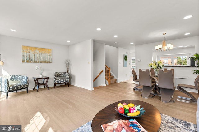 living room featuring an inviting chandelier and light hardwood / wood-style flooring