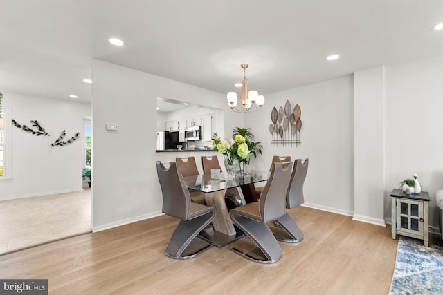 dining space with a notable chandelier and light wood-type flooring