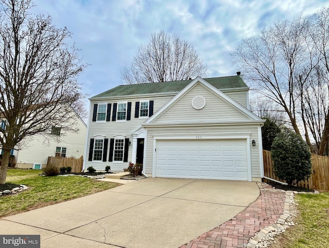 view of front of property featuring an attached garage, fence, and driveway