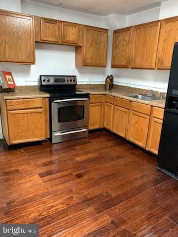 kitchen featuring dark hardwood / wood-style flooring, sink, black fridge, and electric range