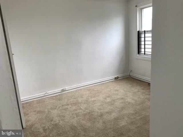 unfurnished room featuring light colored carpet