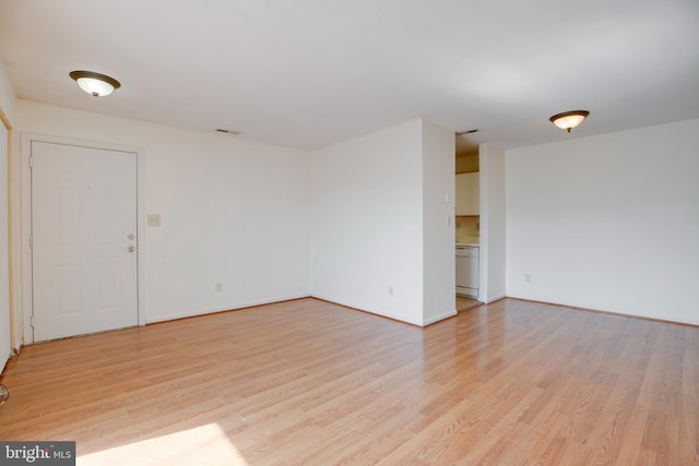 unfurnished room featuring visible vents, light wood-style flooring, and baseboards