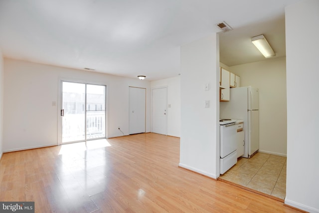 40 Smokewood Ct Unit 200, Stafford, VA 22554 - kitchen featuring light wood finished floors, visible vents, white cabinetry, white appliances, and baseboards