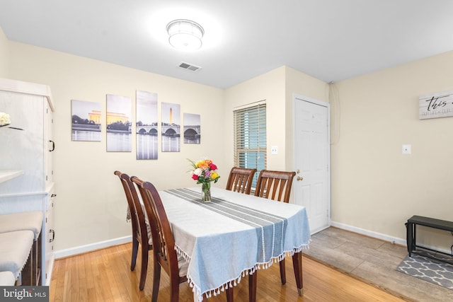 dining room with baseboards, visible vents, and wood finished floors