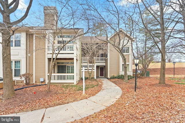 view of property featuring a balcony and a chimney