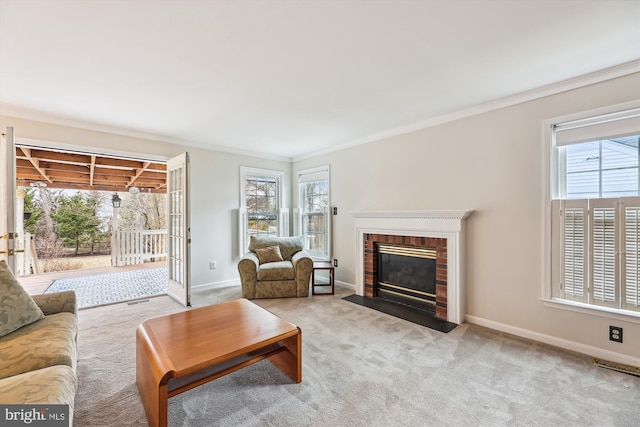 carpeted living room featuring a brick fireplace, visible vents, crown molding, and baseboards