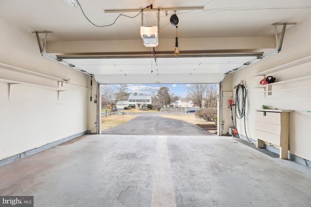 garage featuring a garage door opener and baseboards