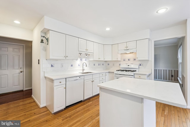 kitchen with white appliances, a sink, white cabinetry, and under cabinet range hood