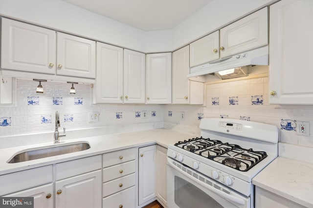 kitchen with decorative backsplash, white cabinetry, a sink, white range with gas stovetop, and under cabinet range hood