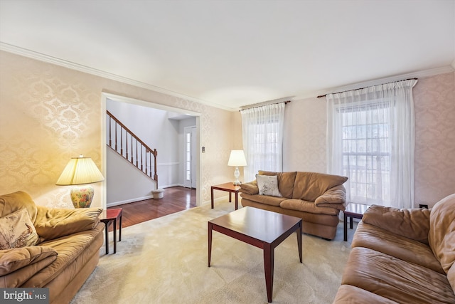 living area featuring stairs, ornamental molding, baseboards, and wallpapered walls