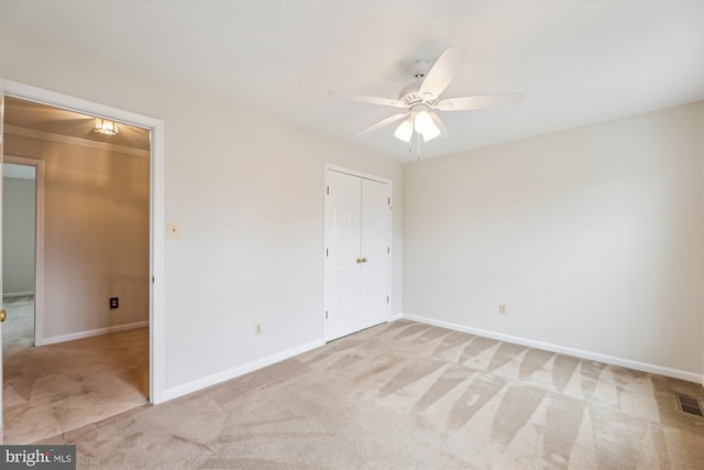 unfurnished bedroom with a ceiling fan, a closet, baseboards, and carpet flooring