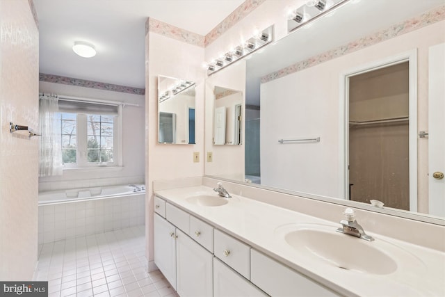 full bathroom featuring tiled tub, double vanity, a sink, and tile patterned floors