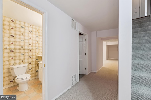 corridor with carpet, visible vents, stairway, and baseboards