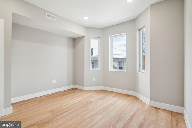 spare room featuring light wood-style flooring, visible vents, baseboards, and recessed lighting