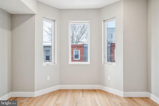 empty room featuring light wood finished floors and baseboards