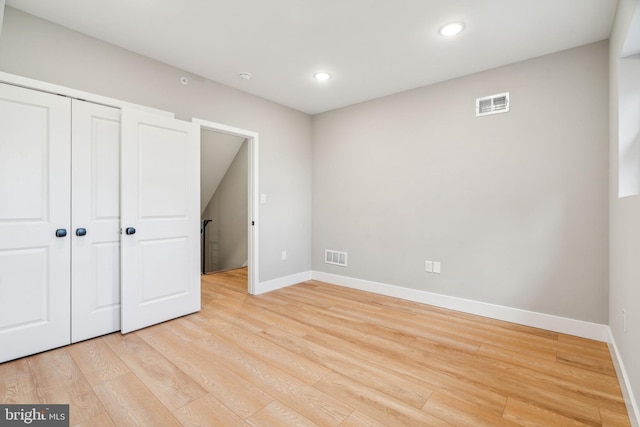 unfurnished bedroom with baseboards, a closet, visible vents, and light wood-style floors