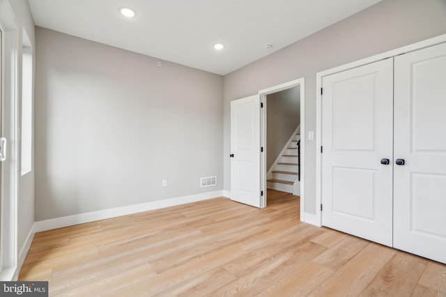 unfurnished bedroom with recessed lighting, a closet, visible vents, light wood-style flooring, and baseboards