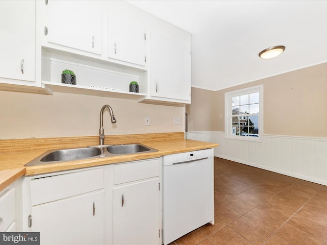 kitchen featuring light tile patterned flooring, white cabinetry, white dishwasher, and sink