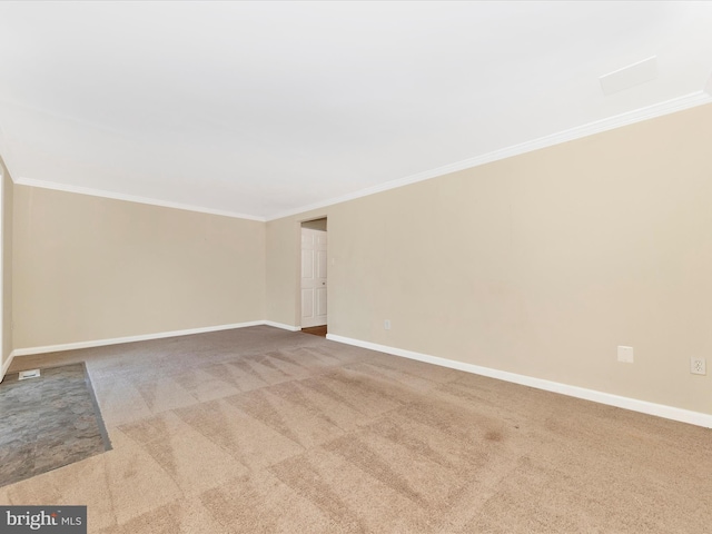 empty room featuring crown molding and light colored carpet