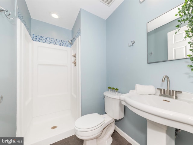 bathroom featuring sink, a shower, toilet, and tile patterned floors