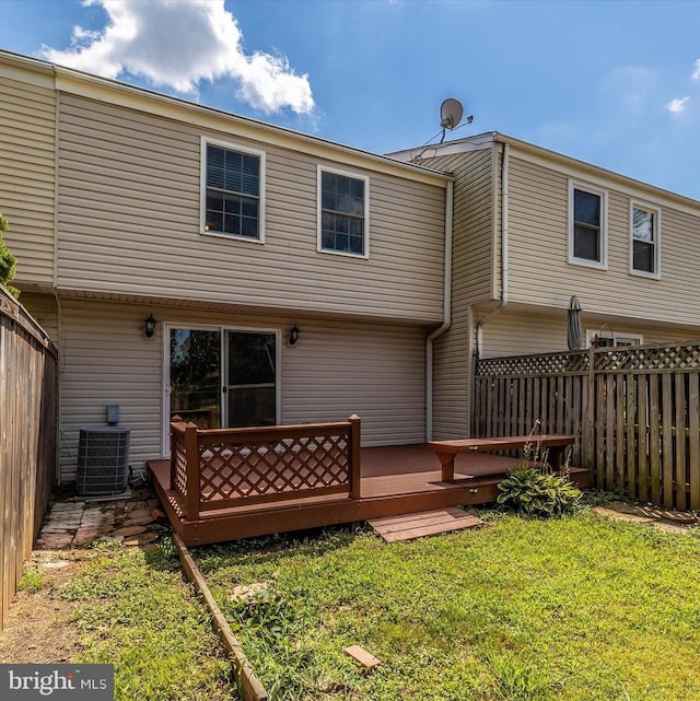 back of house featuring cooling unit, a lawn, and a wooden deck