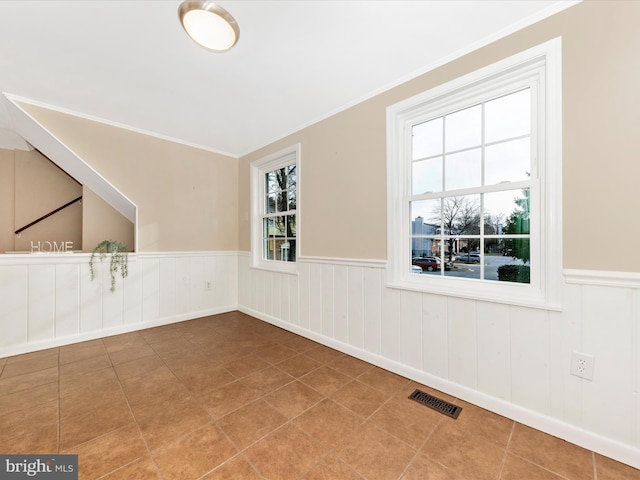 spare room with tile patterned flooring and ornamental molding