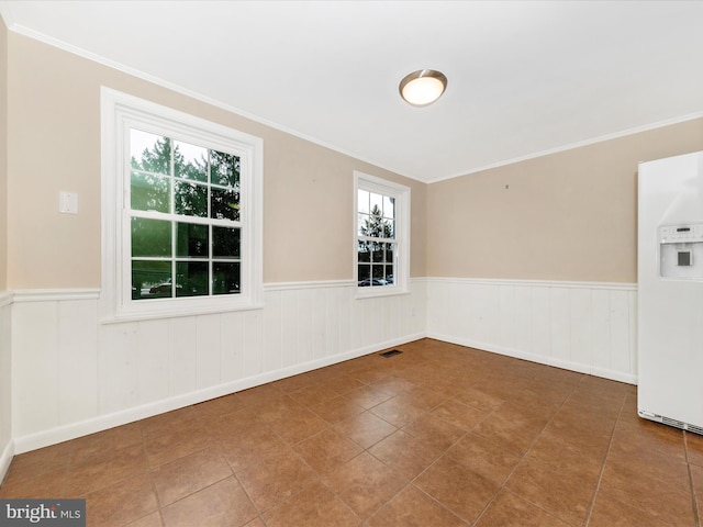 empty room with ornamental molding and tile patterned flooring