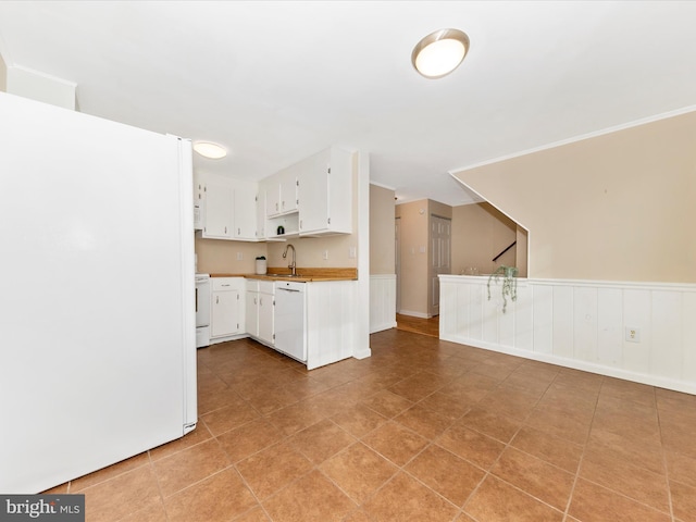 kitchen featuring sink, white appliances, white cabinets, and light tile patterned floors