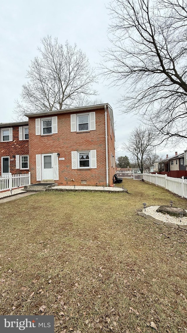 view of front of home featuring brick siding, a front yard, and fence