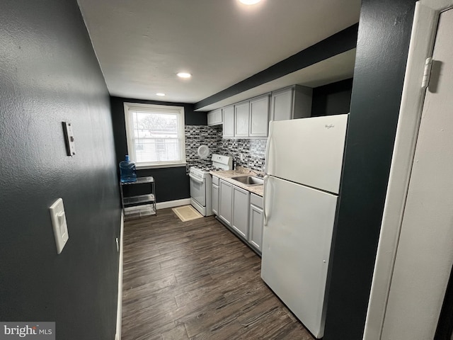 kitchen with sink, dark wood-type flooring, white appliances, and decorative backsplash