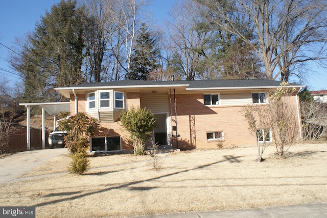 view of front facade featuring driveway, brick siding, and an attached carport