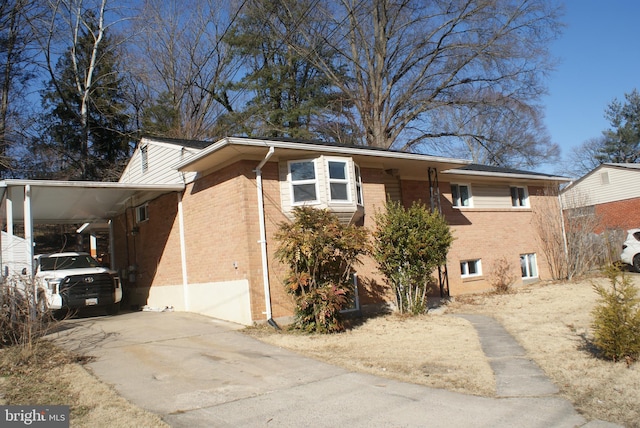 view of property exterior featuring an attached carport, concrete driveway, and brick siding