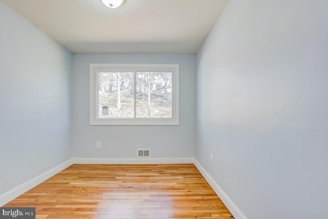 unfurnished room with light wood-style flooring, visible vents, and baseboards