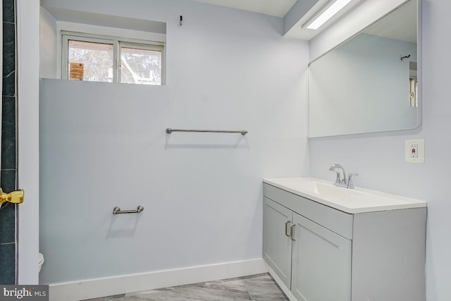 bathroom featuring baseboards, vanity, and toilet