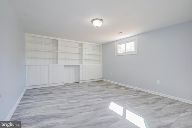 interior space featuring light wood-style floors, visible vents, and baseboards