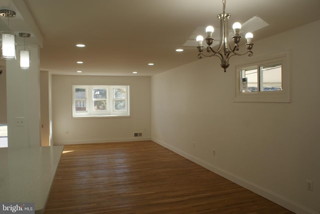 spare room featuring baseboards, visible vents, wood finished floors, a chandelier, and recessed lighting