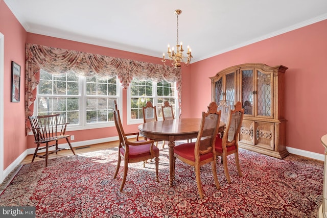 dining room featuring hardwood / wood-style floors, crown molding, and a notable chandelier