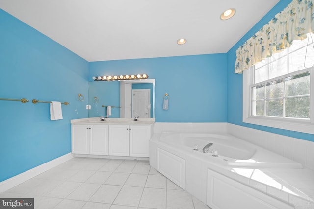 bathroom with tile patterned flooring, vanity, and a relaxing tiled tub