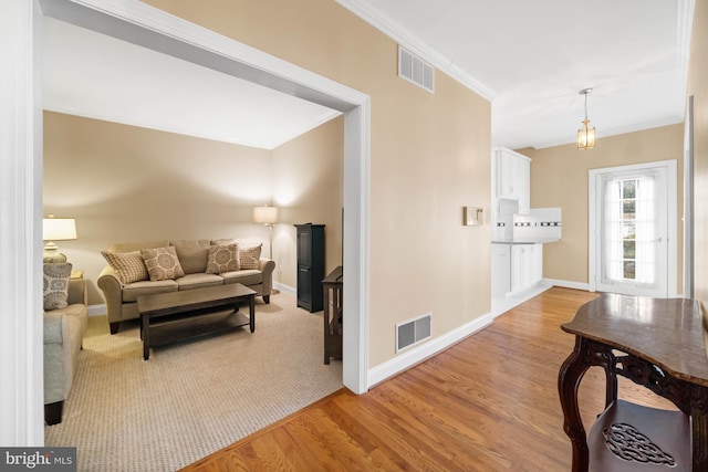 living room with light hardwood / wood-style flooring and crown molding