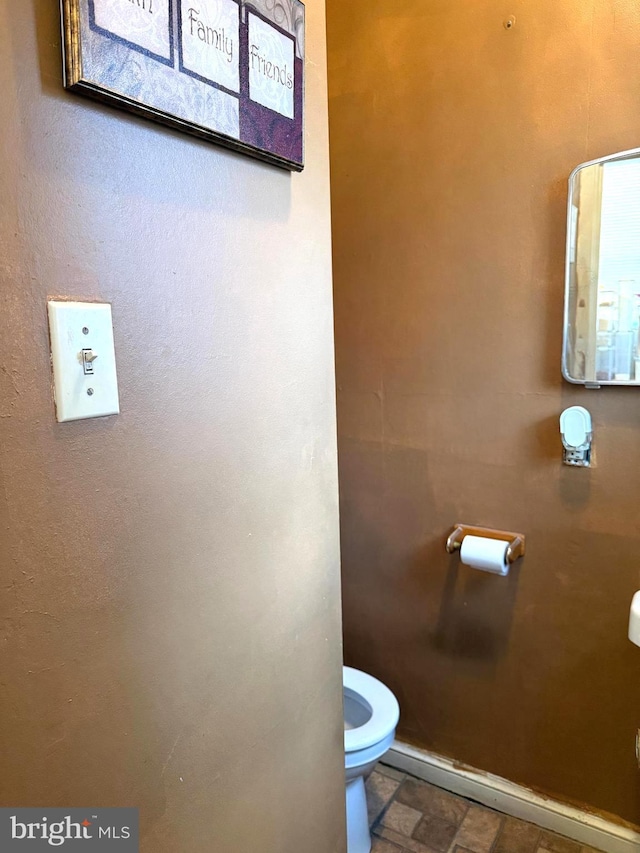 bathroom featuring toilet and stone finish floor